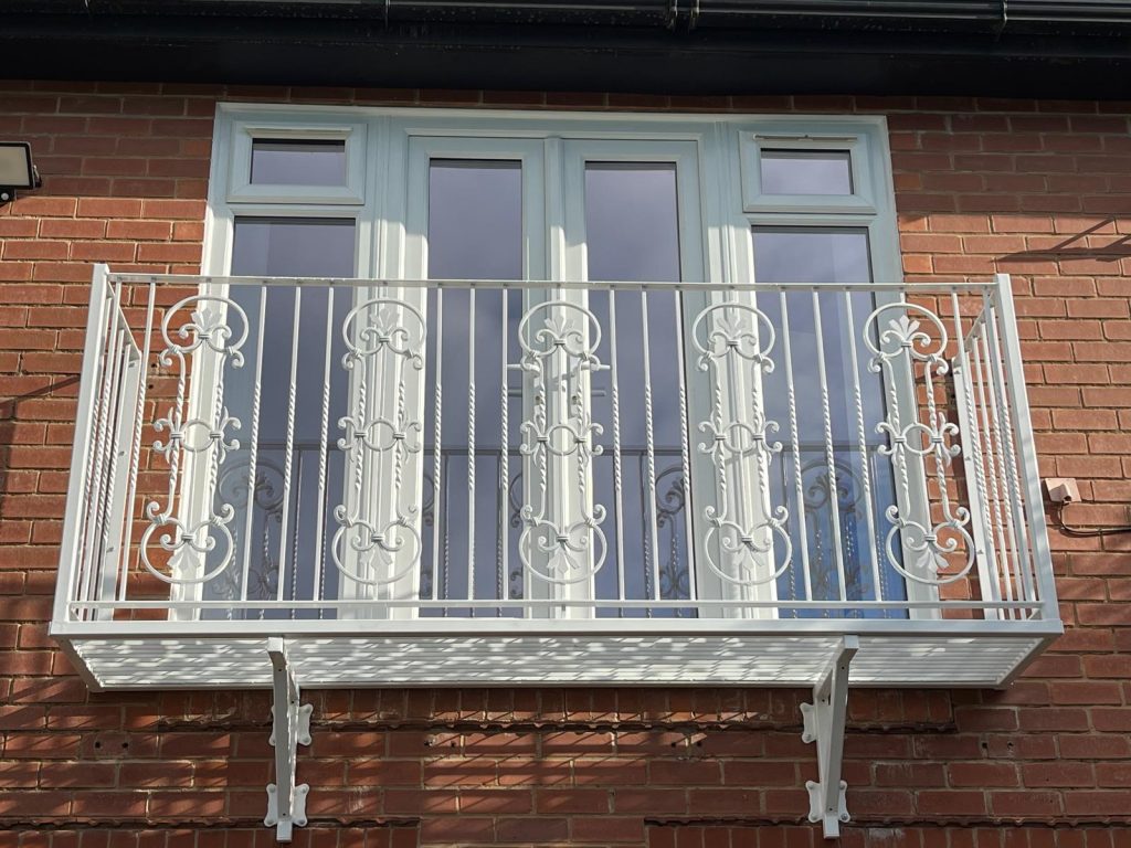 White Heritage Juliet balcony with scroll detail, fitted to a brick house