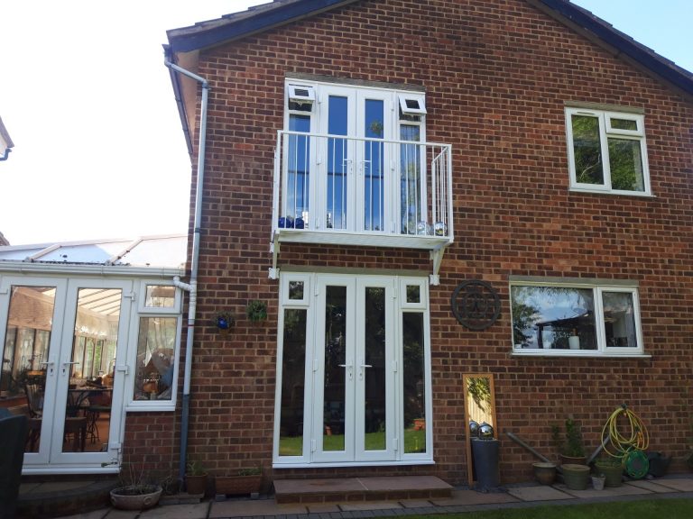 White steel Juliet balcony on a red-brick house