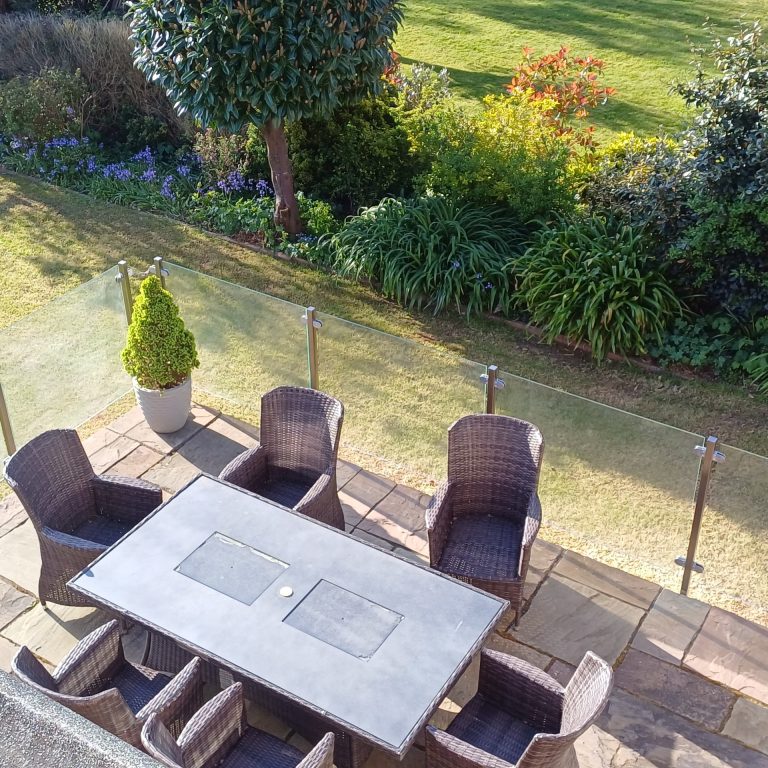 Glass balustrade around a garden patio